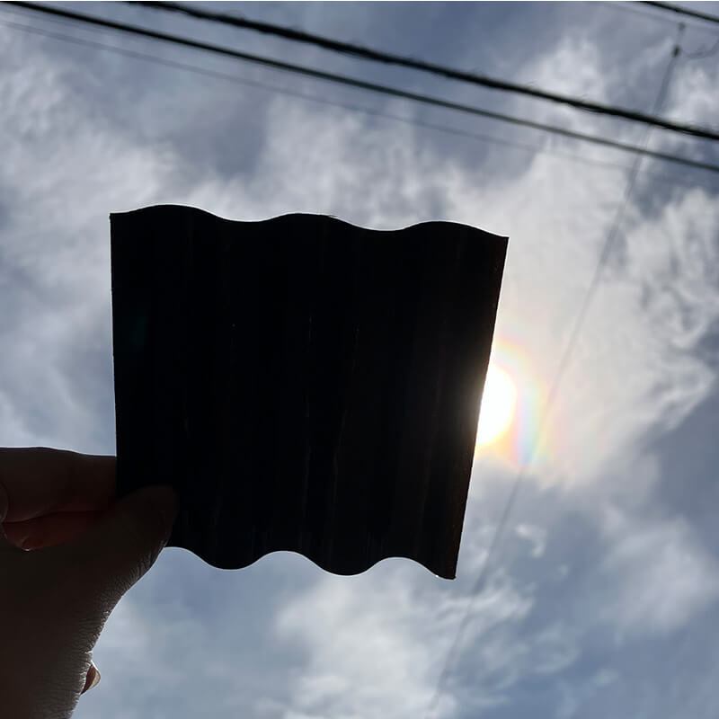 ポリカ波板 エコブラックを太陽にかざした参考写真